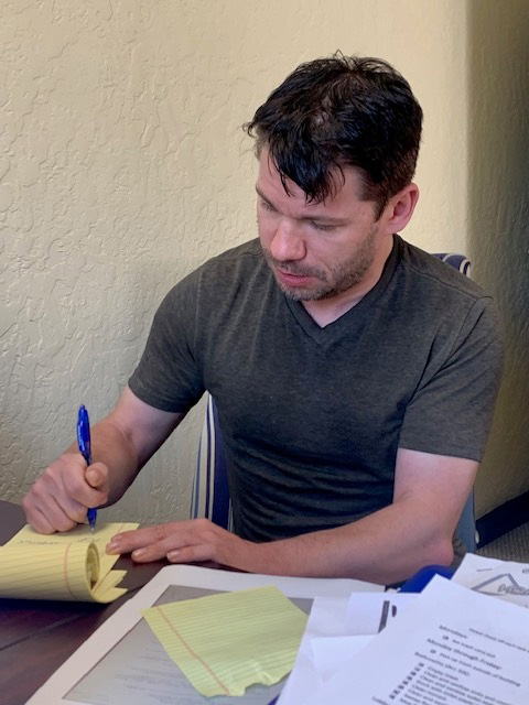 A man sits at a desk and fills out paperwork