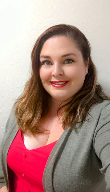 A headshot of a smiling woman in a professional outfit